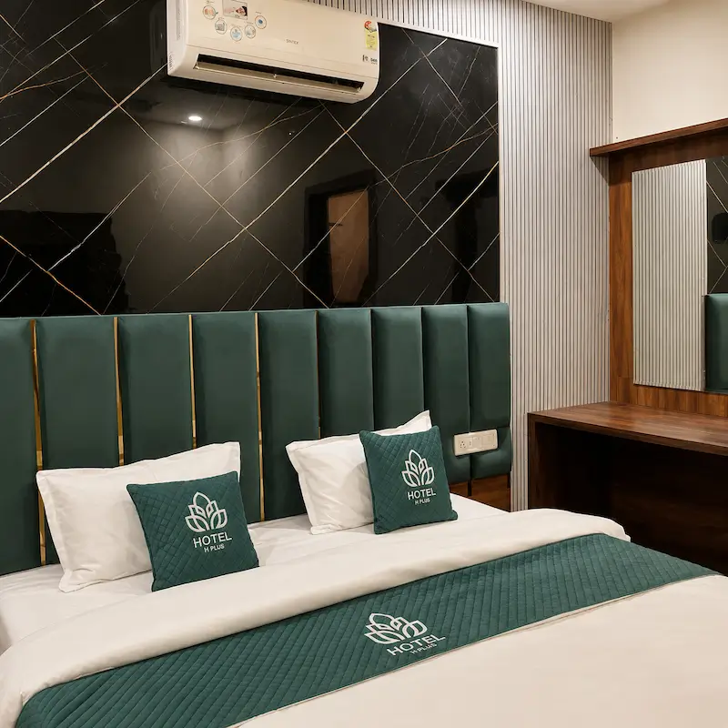 Deluxe room with green upholstered headboard