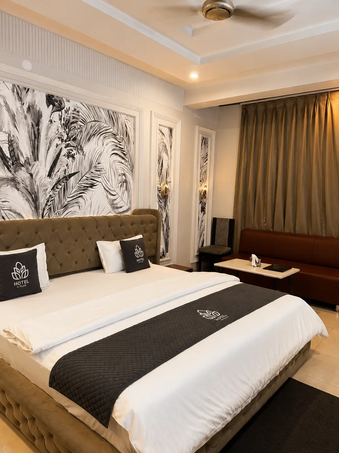 Premium hotel room with tufted bed and sofa seating